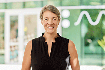 Michelle Simmons portrait photo, wearing a black top and smiling at the camera. Blurred backround.